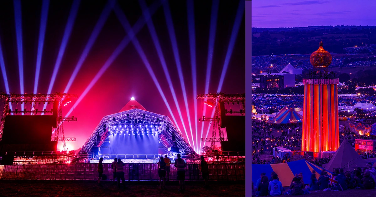 Large-scale festival stage surrounded by immersive lighting, towering structures, and visitors exploring Glastonbury's temporary event city. 